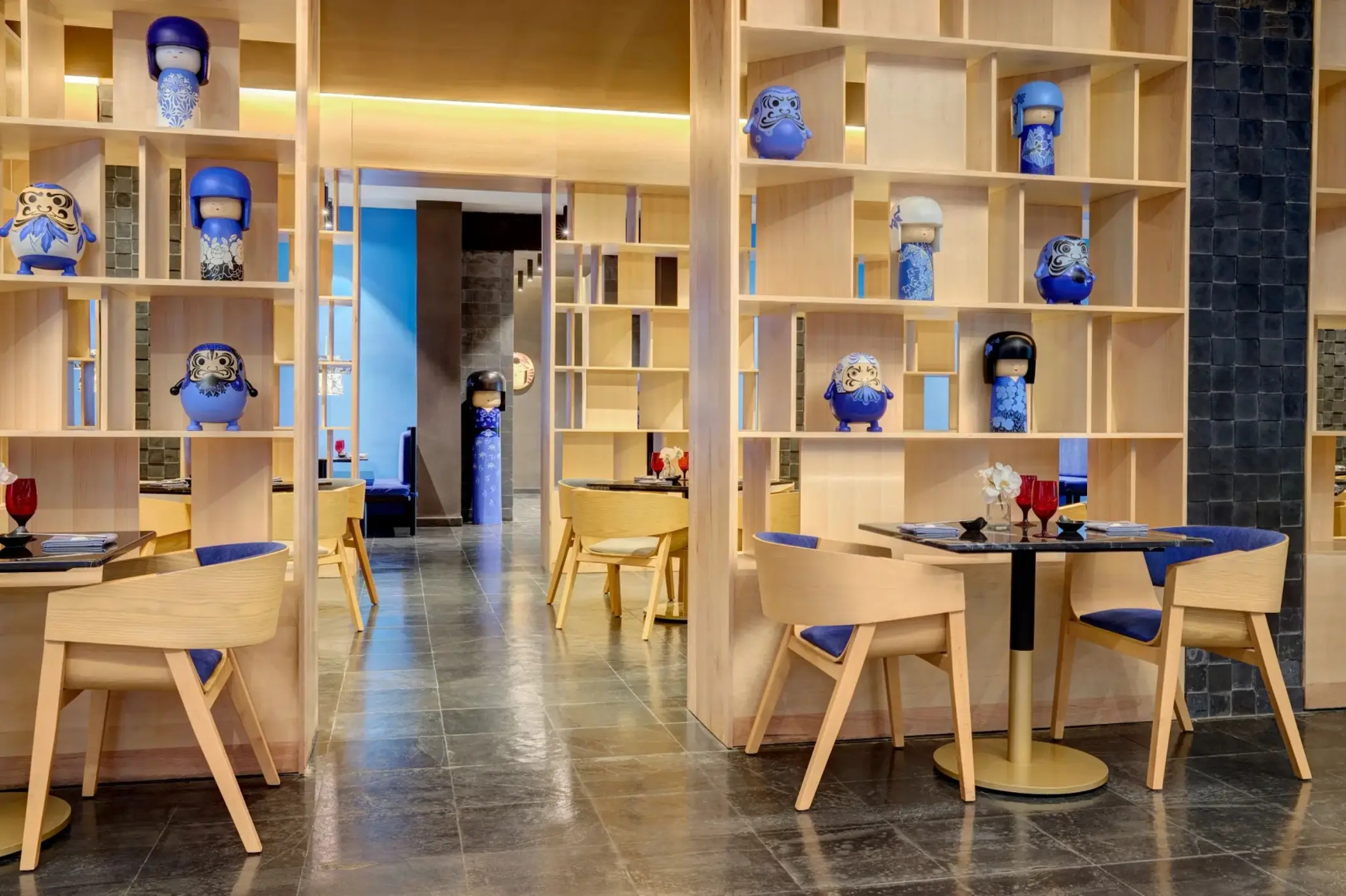 Japanese restaurant dining area with blue kokeshi dolls on shelving at Dreams Puerto Morelos, Riviera Maya