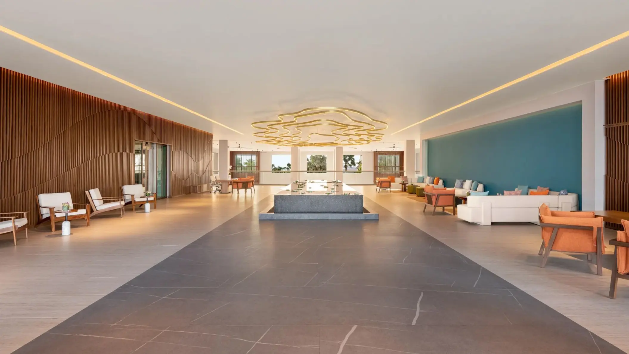 Modern lobby with a gold chandelier and teal accents at Dreams Puerto Morelos, Riviera Maya