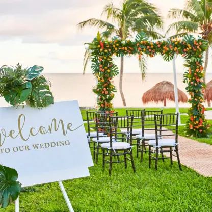 Mango Garden wedding ceremony with floral arch and welcome sign at Dreams Puerto Morelos, Riviera Maya