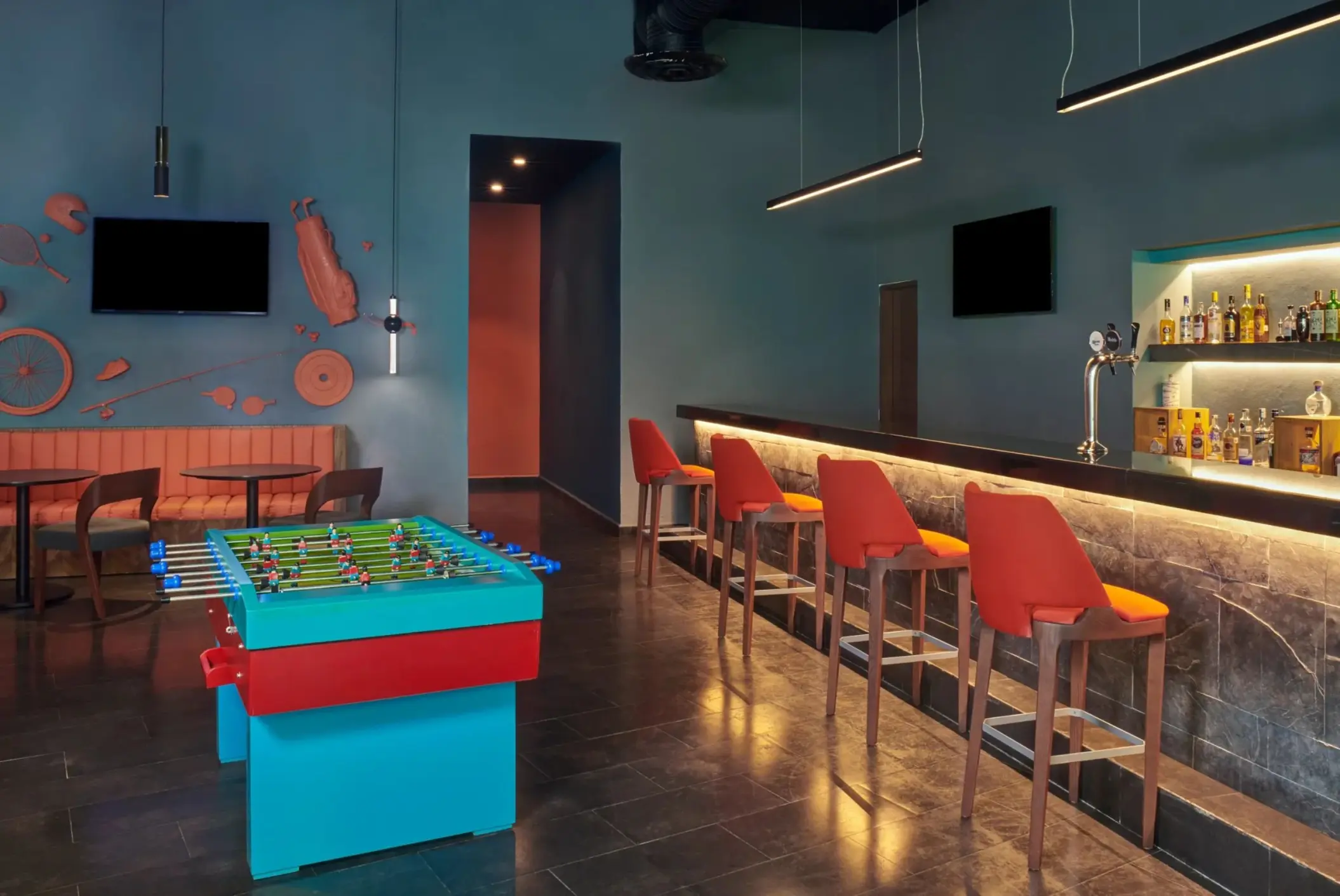 Off Court Sports Bar featuring a foosball table and red bar stools at Dreams Puerto Morelos, Riviera Maya