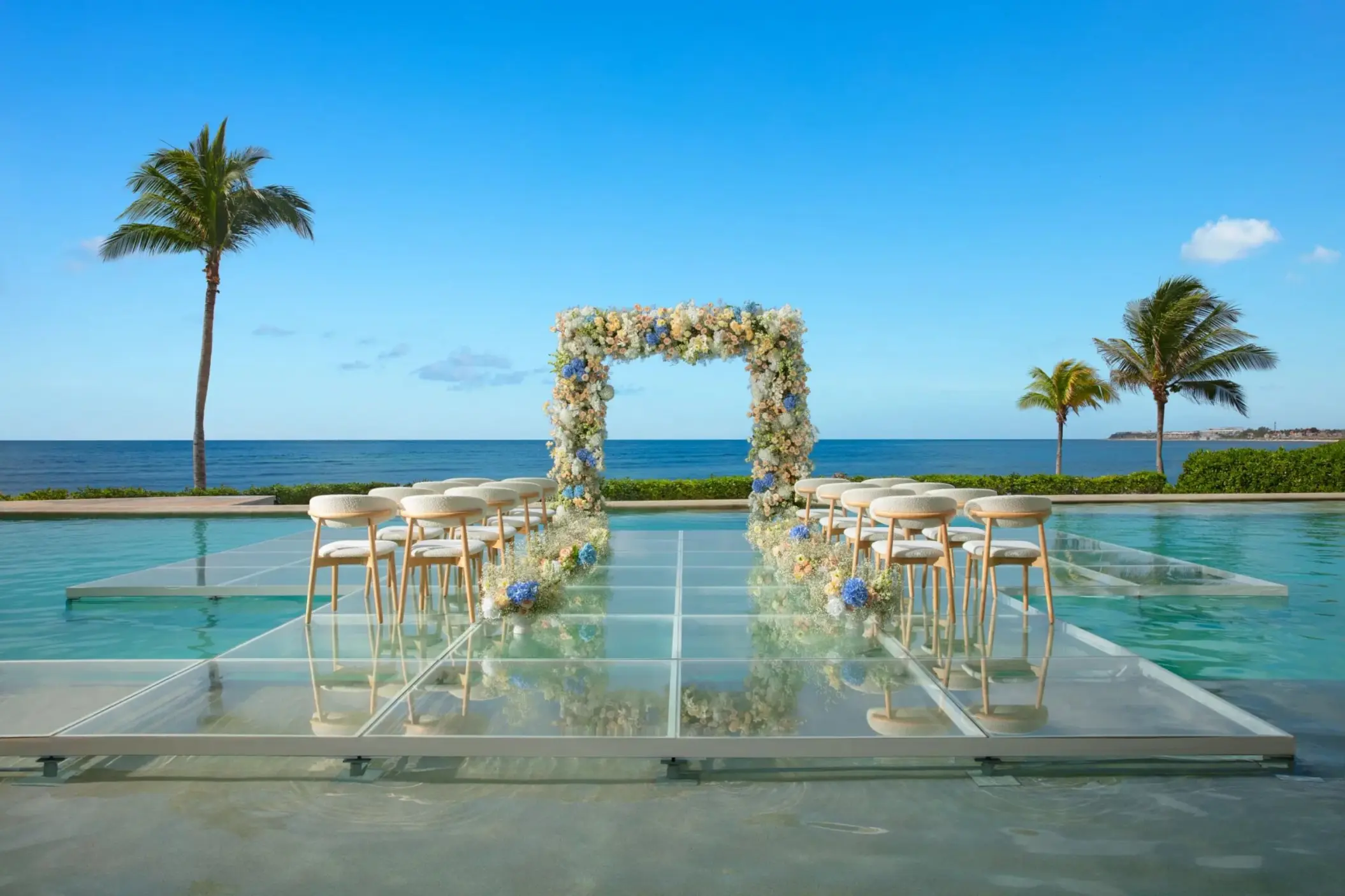 Overwater wedding ceremony setup on a glass platform at Dreams Puerto Morelos, Riviera Maya
