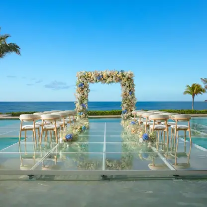 Overwater wedding ceremony setup on a glass platform at Dreams Puerto Morelos, Riviera Maya
