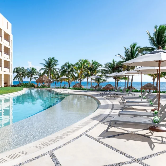 pool and poolside loungers and resort building at Dreams Puerto Morelos Resort & Spa