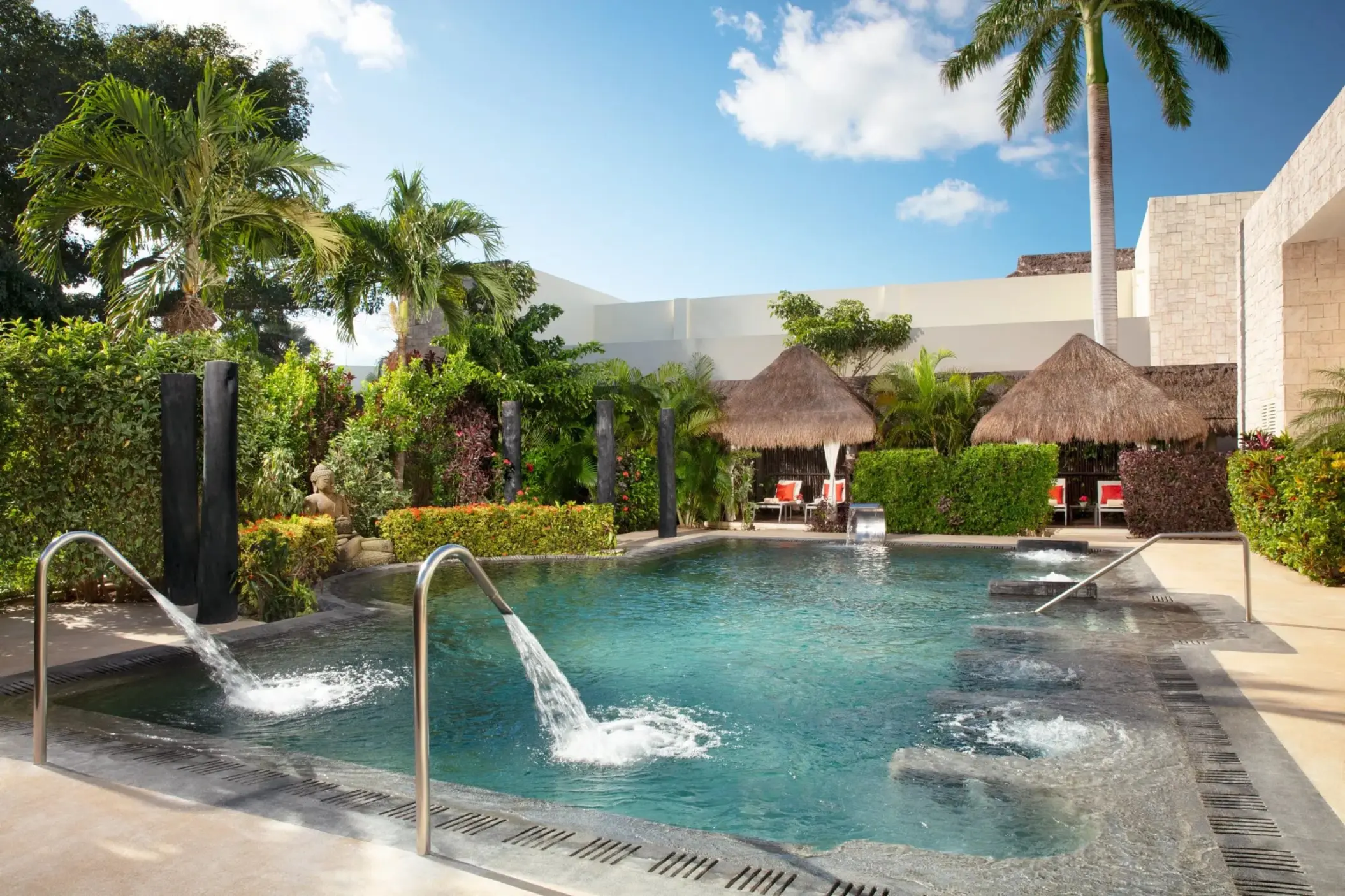 Outdoor hydrotherapy spa pool with water fountains and palapas at Dreams Puerto Morelos, Riviera Maya