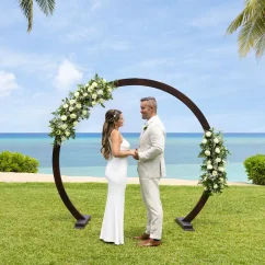A bride and groom standing at the resort's West Lawn wedding venue with the ocean in the background.