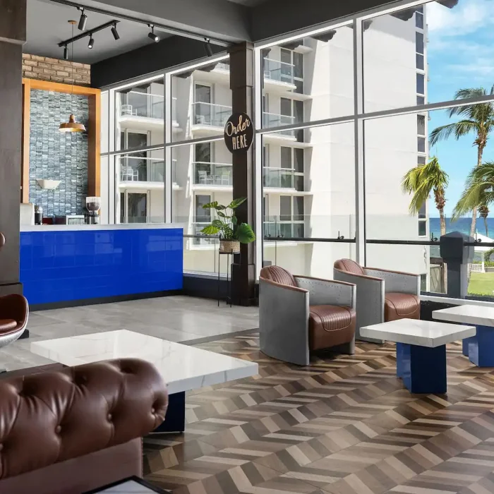 Inside the resort's coffee shop with large windows offering a beautiful view of the beach and ocean.