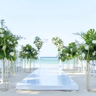 Beachfront wedding ceremony with white flowers and tropical greenery at Dreams Rose Hall, Montego Bay