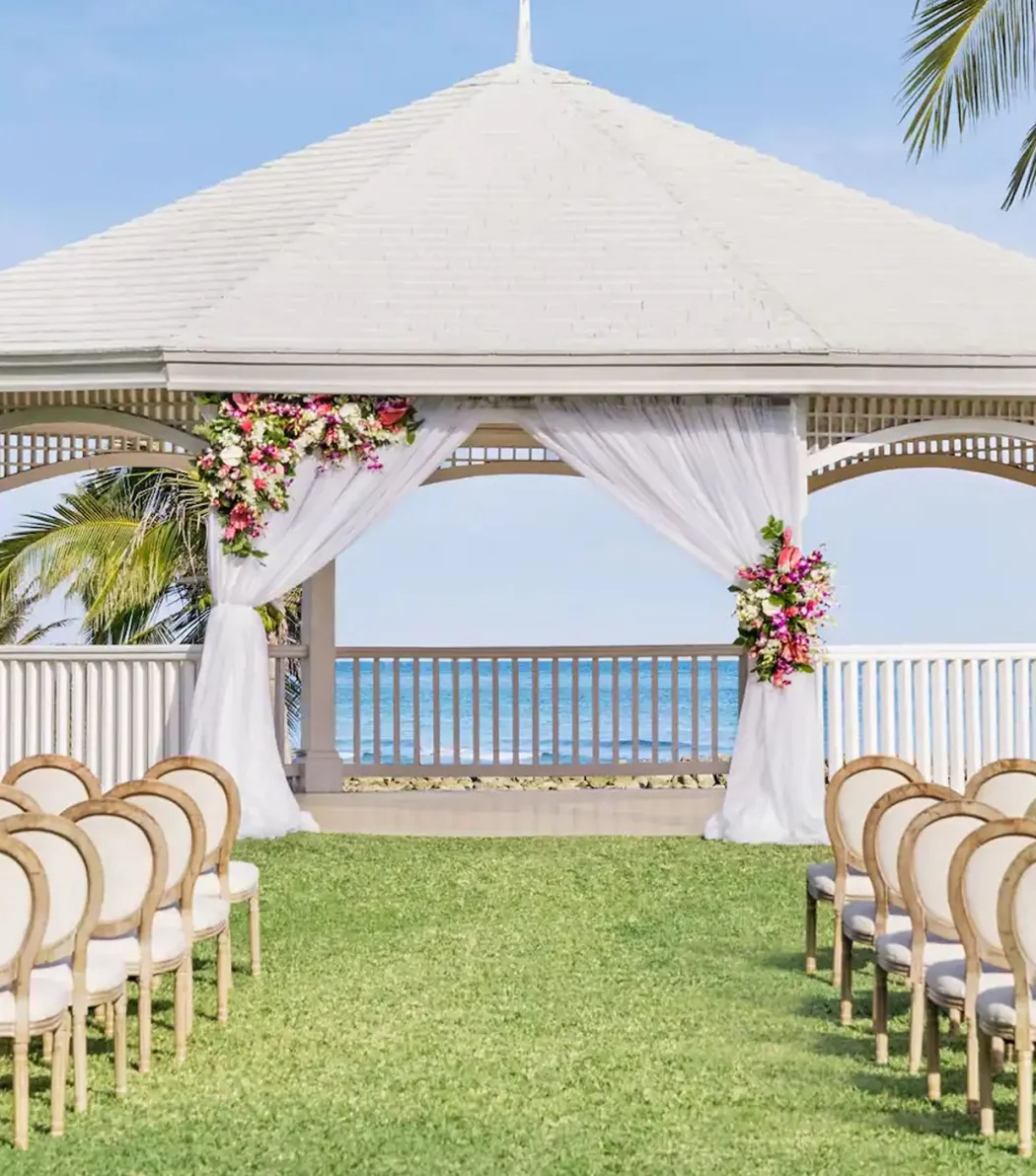 A charming gazebo wedding venue at the resort, decorated with flowers and overlooking the stunning ocean.
