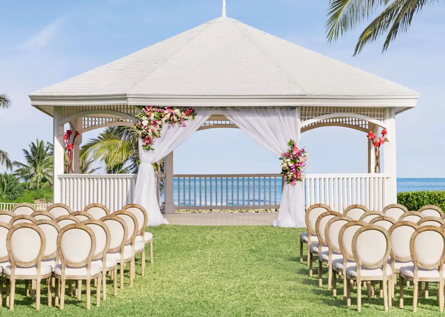A charming gazebo wedding venue at the resort, decorated with flowers and overlooking the stunning ocean.