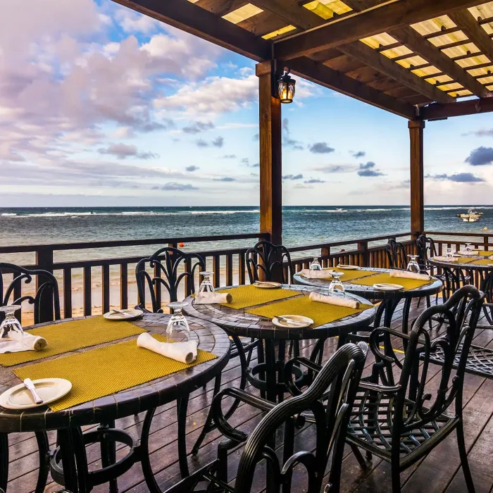 The Moonstone Di Mare restaurant's outdoor deck with dining tables, chairs, and a breathtaking ocean view.