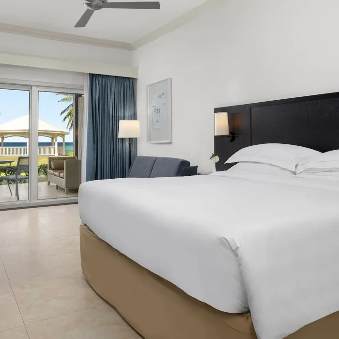 An Oceanfront Walkout King room with a large bed and direct access to a private patio and the lawn.