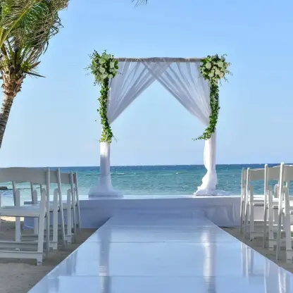 Beachfront wedding ceremony with white draped arch at Dreams Rose Hall, Montego Bay