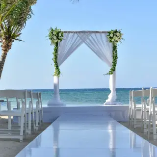 Beachfront wedding ceremony with white draped arch at Dreams Rose Hall, Montego Bay