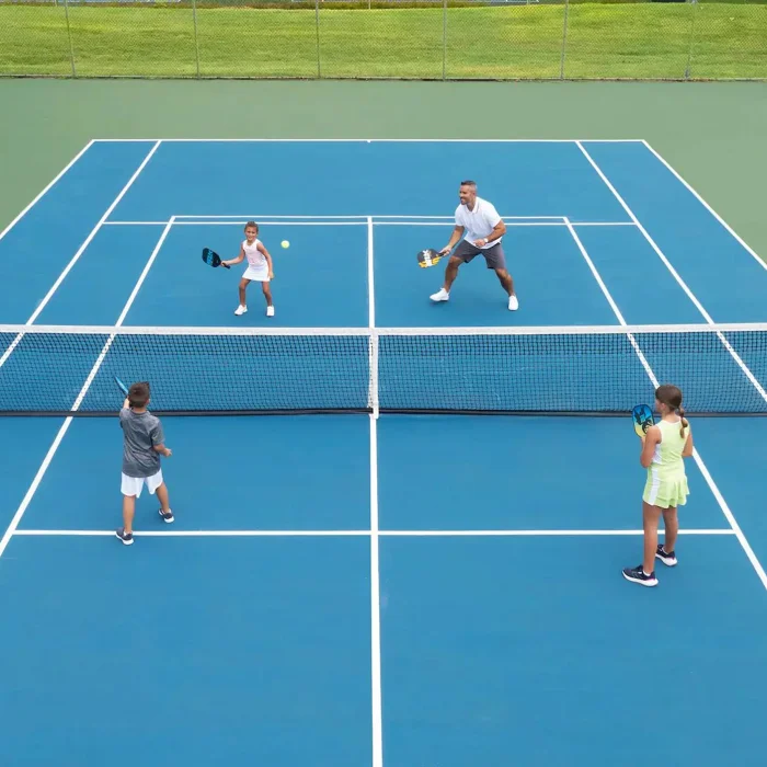 A family playing a game of tennis on one of the resort's well-maintained blue and green tennis courts.