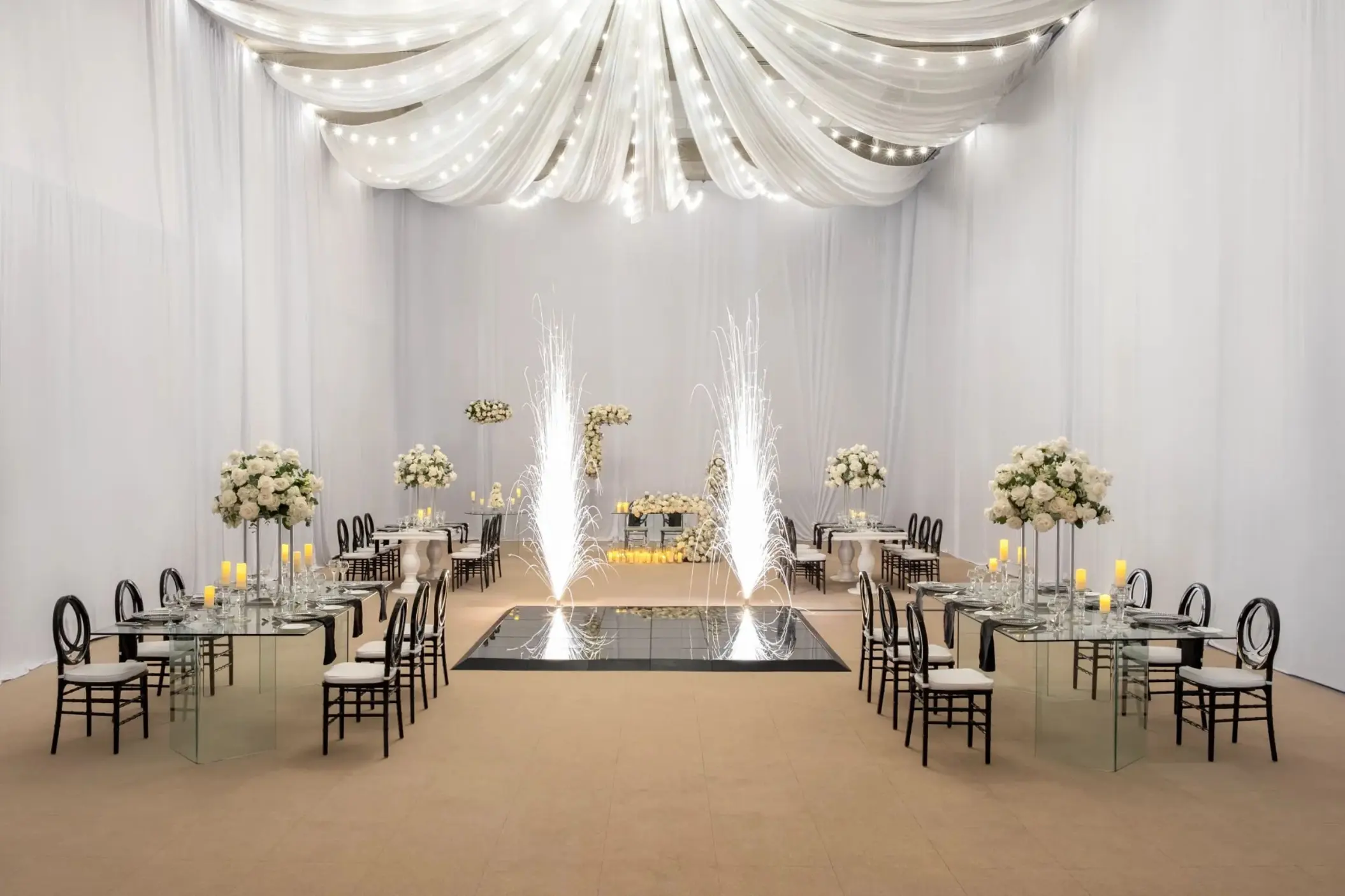 Ballroom wedding reception with cold spark fountains and white drapery at Dreams Royal Beach, Punta Cana