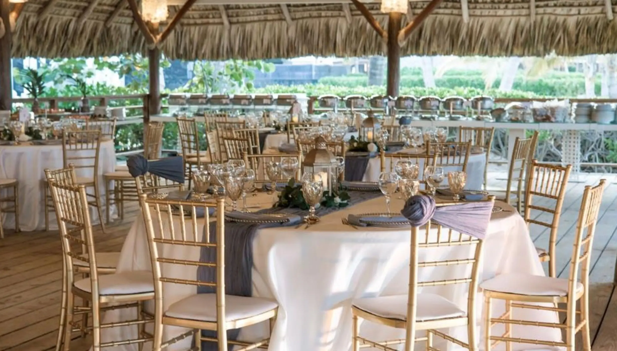 Seaside Grill wedding reception setup under a thatched palapa at Dreams Royal Beach, Punta Cana
