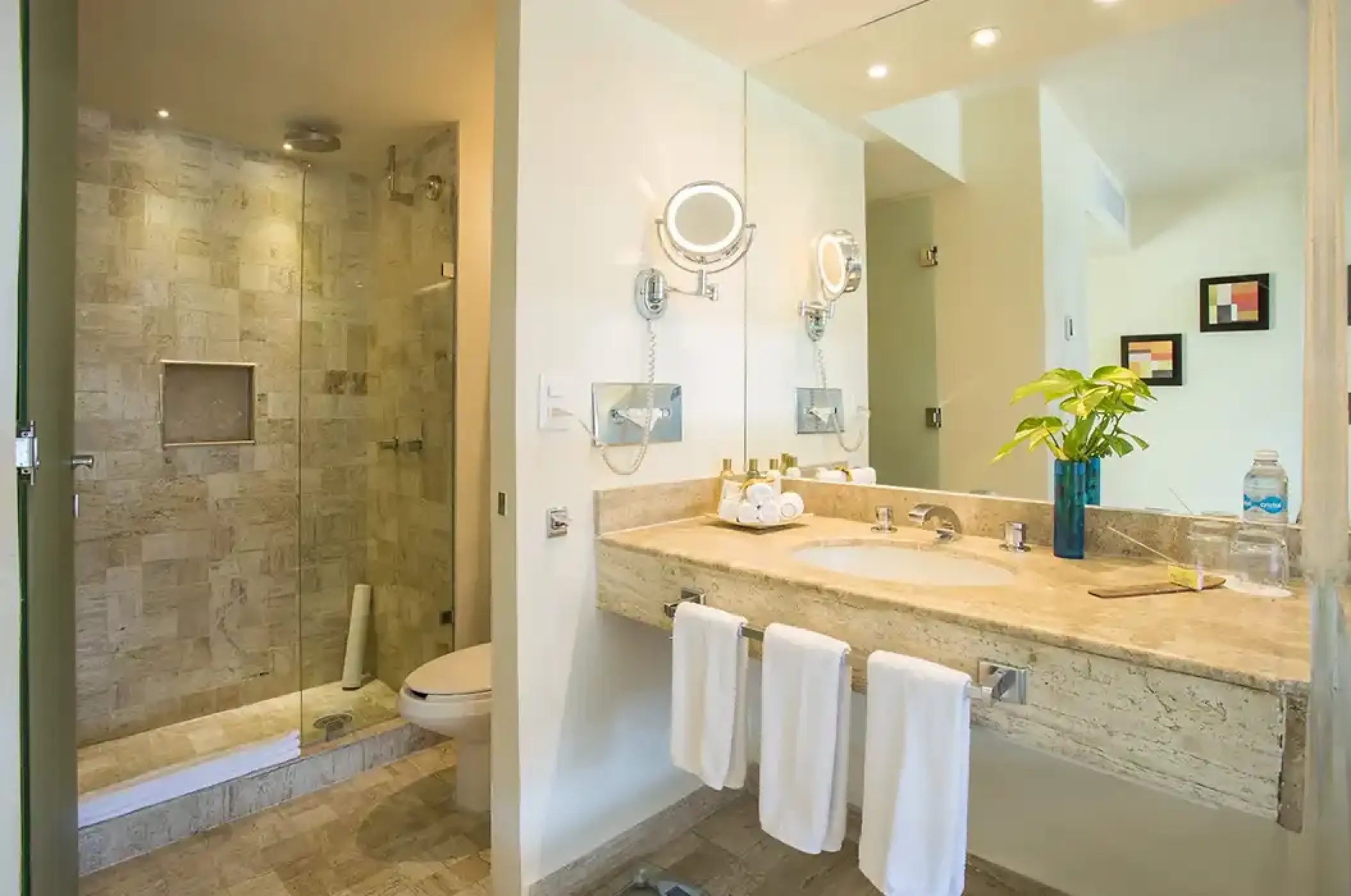 Modern bathroom with stone walk-in shower and marble vanity at Dreams Sands Cancun, Cancun