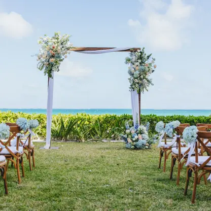 Jardin del Mar wedding ceremony setup with floral arch at Dreams Sapphire, Riviera Maya