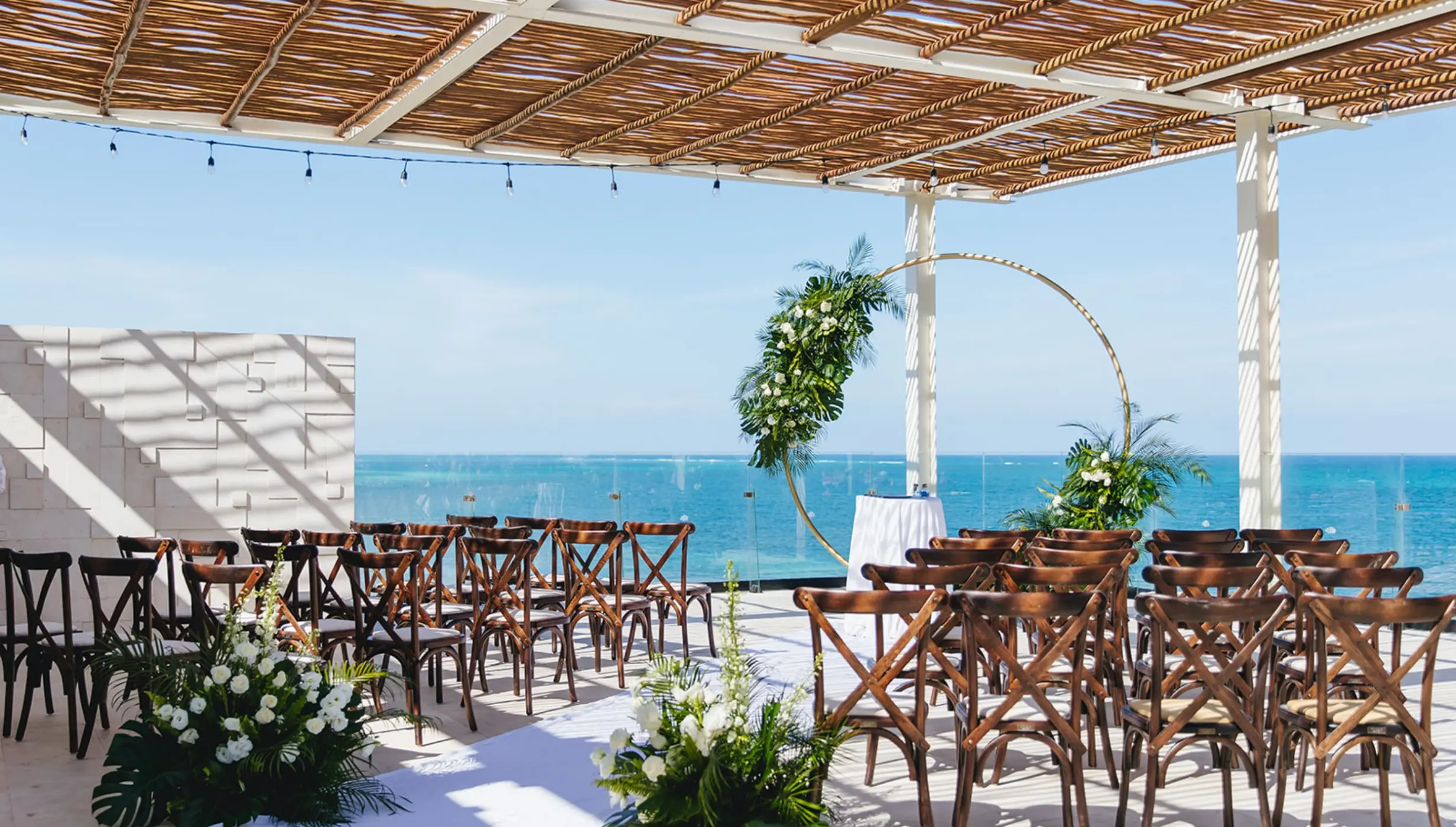 Rooftop wedding ceremony under a trellis overlooking the ocean at Dreams Sapphire, Riviera Maya