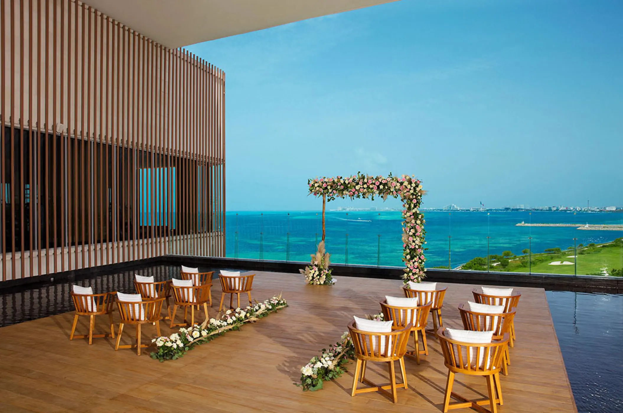 Rooftop terrace wedding ceremony setup with floral arch at Dreams Vista Cancun