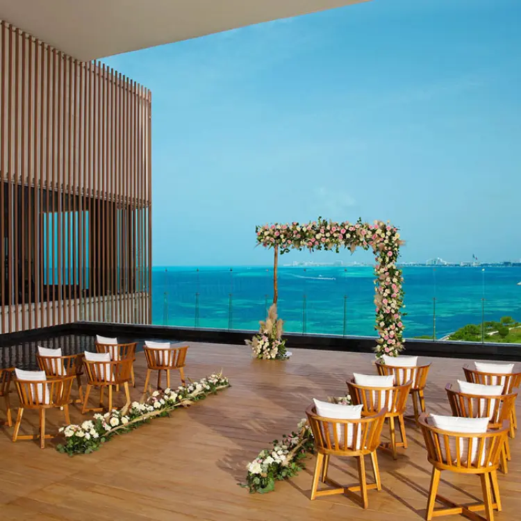 Rooftop terrace wedding ceremony setup with floral arch at Dreams Vista Cancun