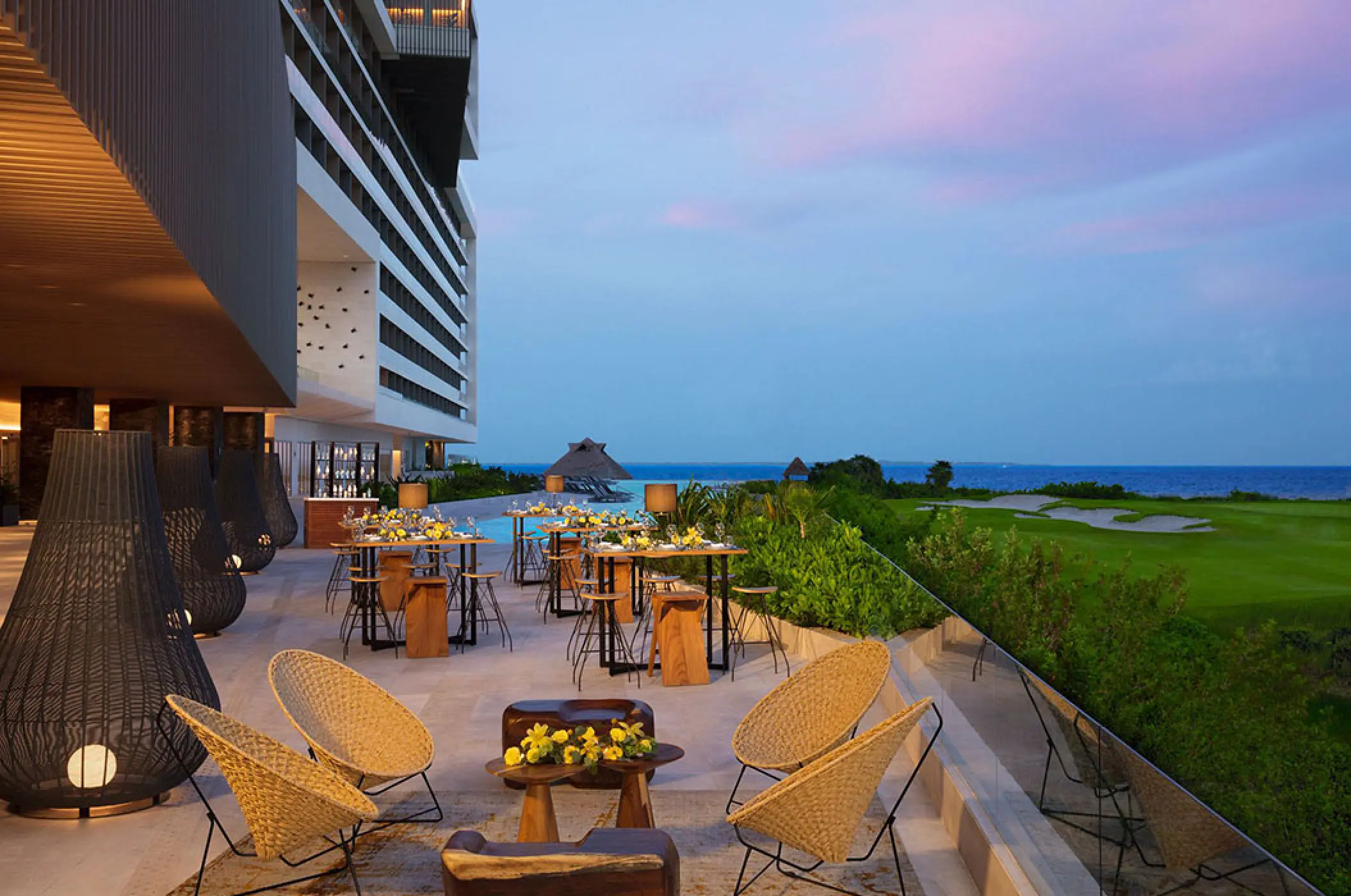 Outdoor terrace with seating and high-top tables overlooking the ocean at Dreams Vista Cancun, Cancun