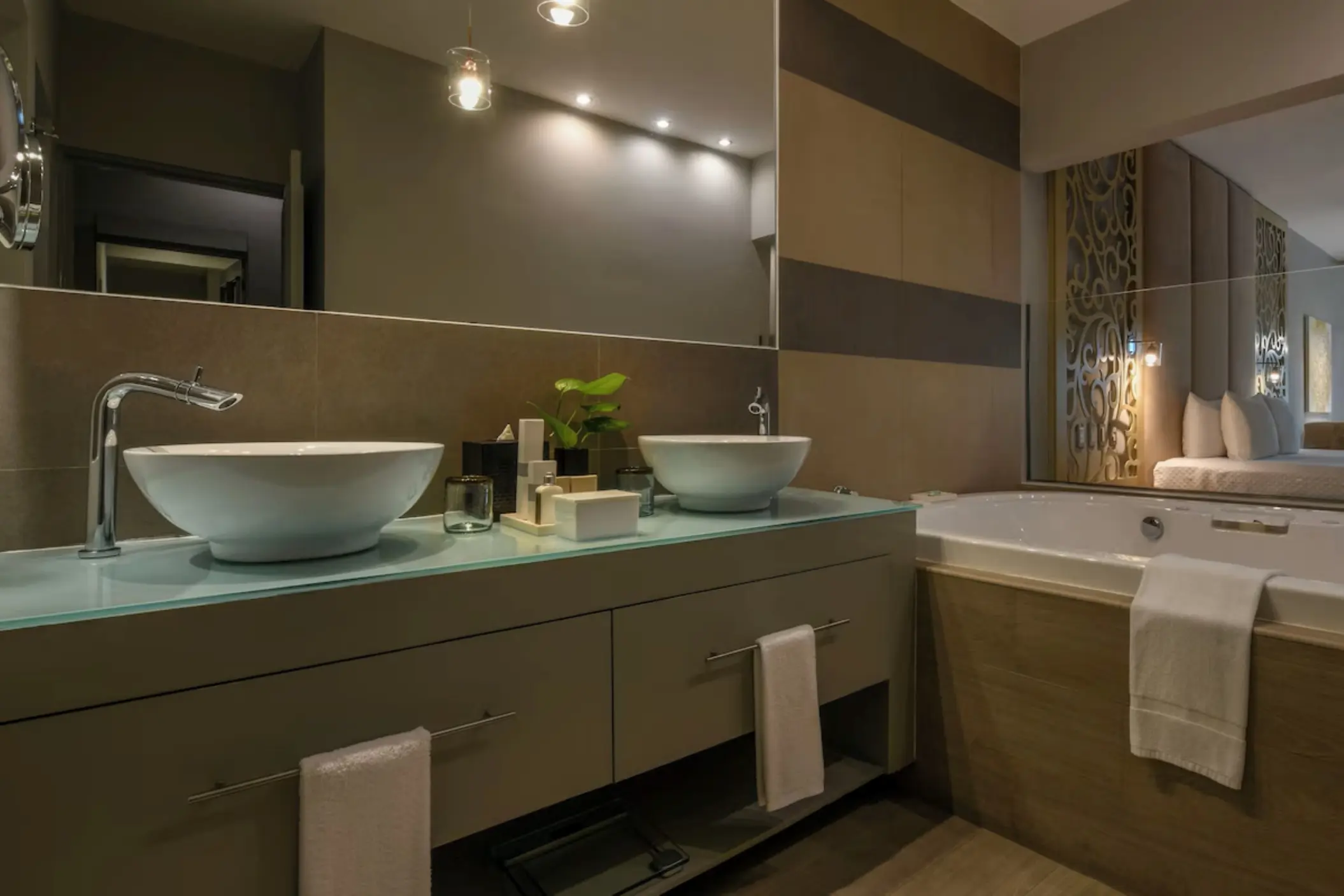 Modern suite bathroom with double vessel sinks and a jacuzzi tub at El Dorado Royale, Riviera Maya