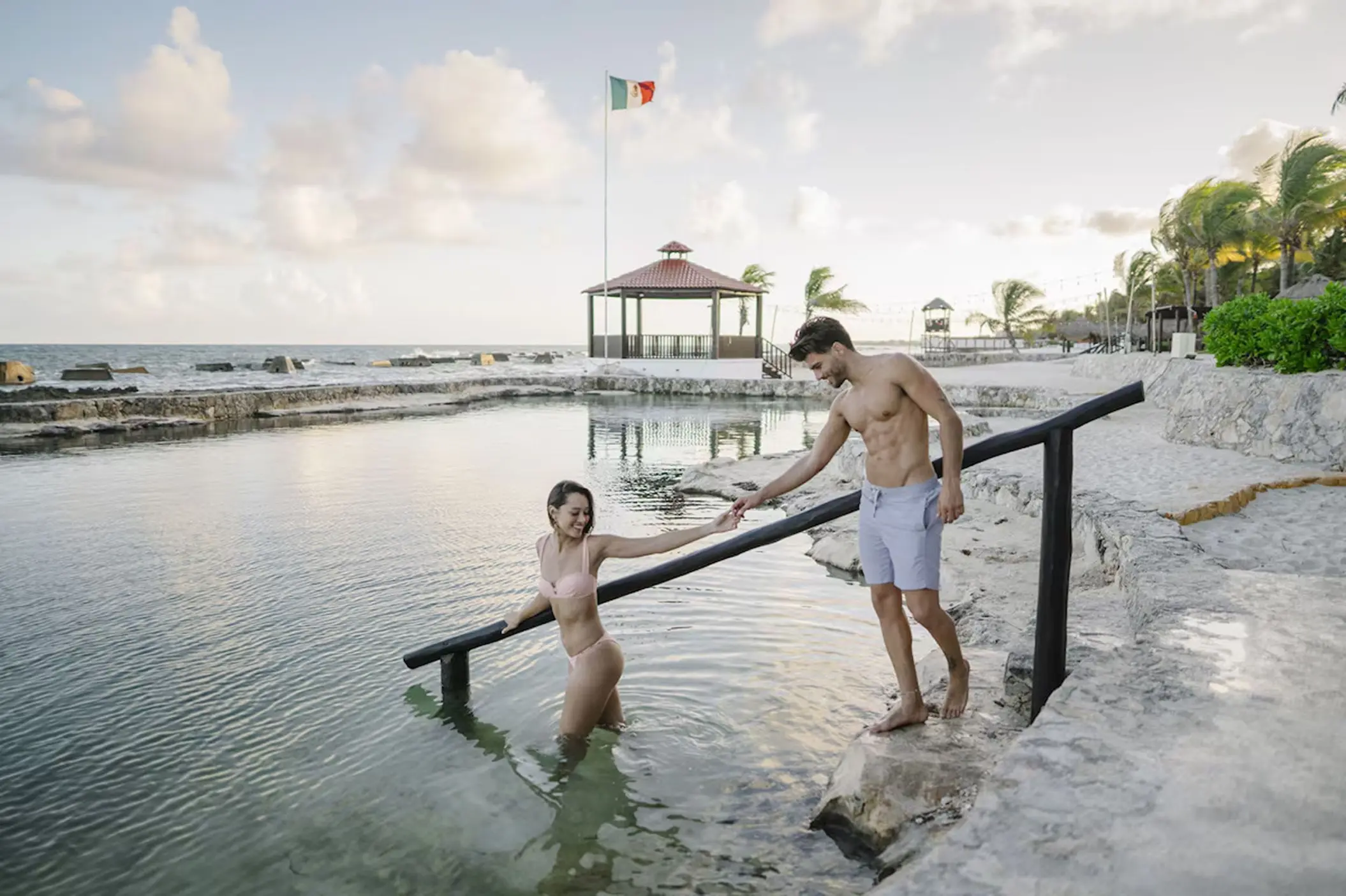 Couple wading into the saltwater pool at El Dorado Royale, Riviera Maya