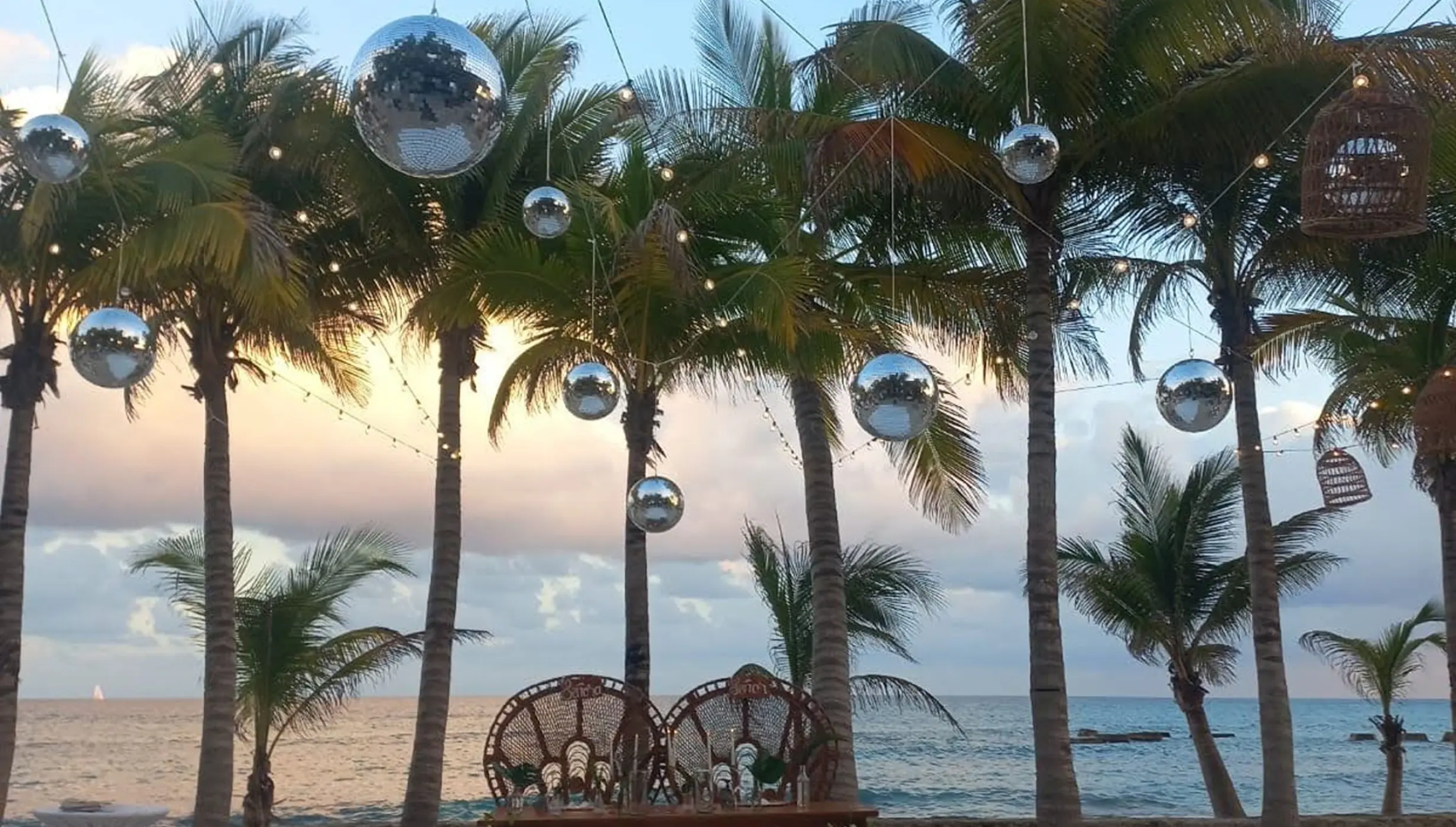 Beachfront wedding reception setup with disco balls and a dance floor at El Dorado Royale, Riviera Maya