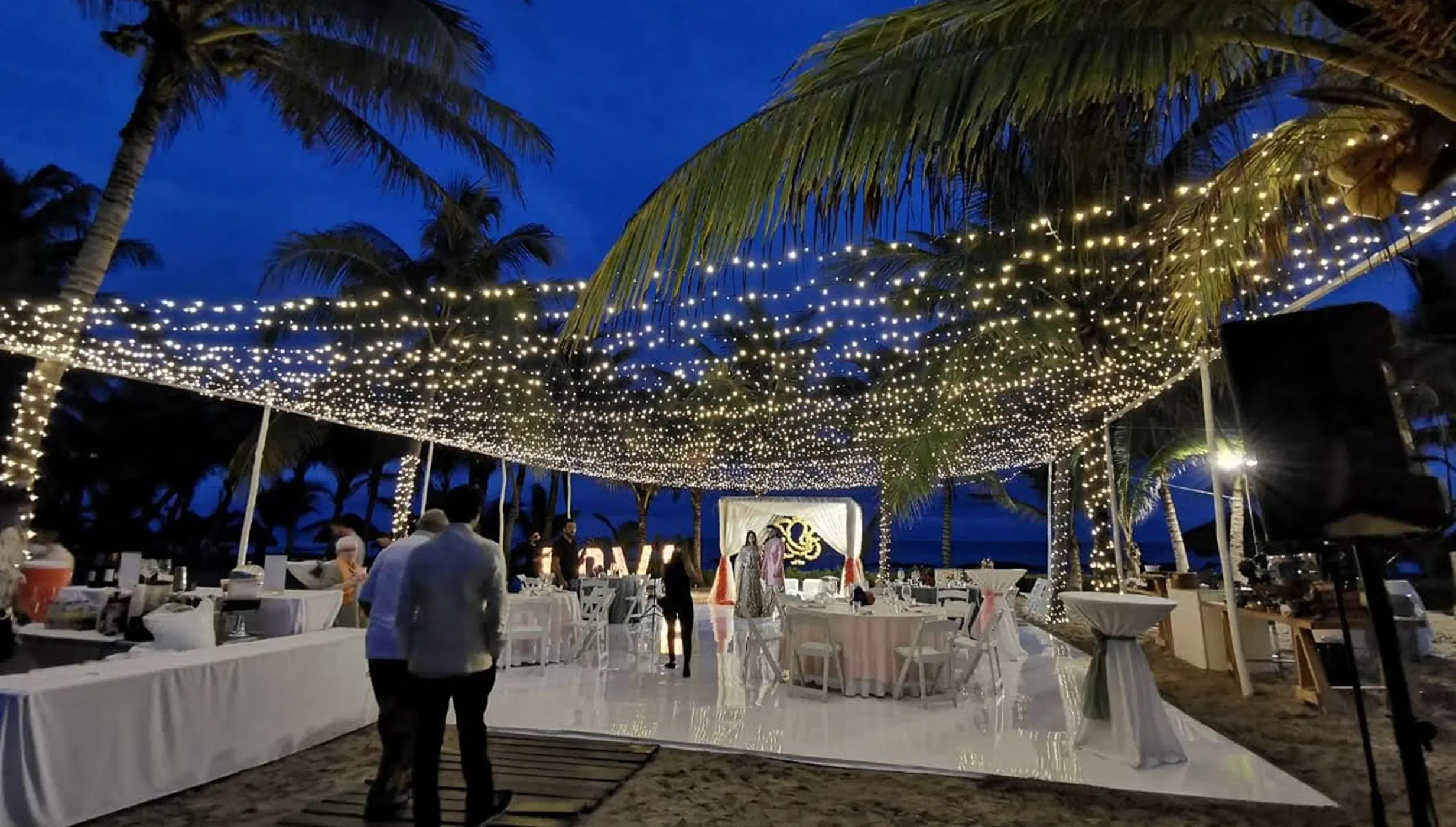 Fuentes venue evening reception with fairy lights and white dance floor at El Dorado Royale, Riviera Maya