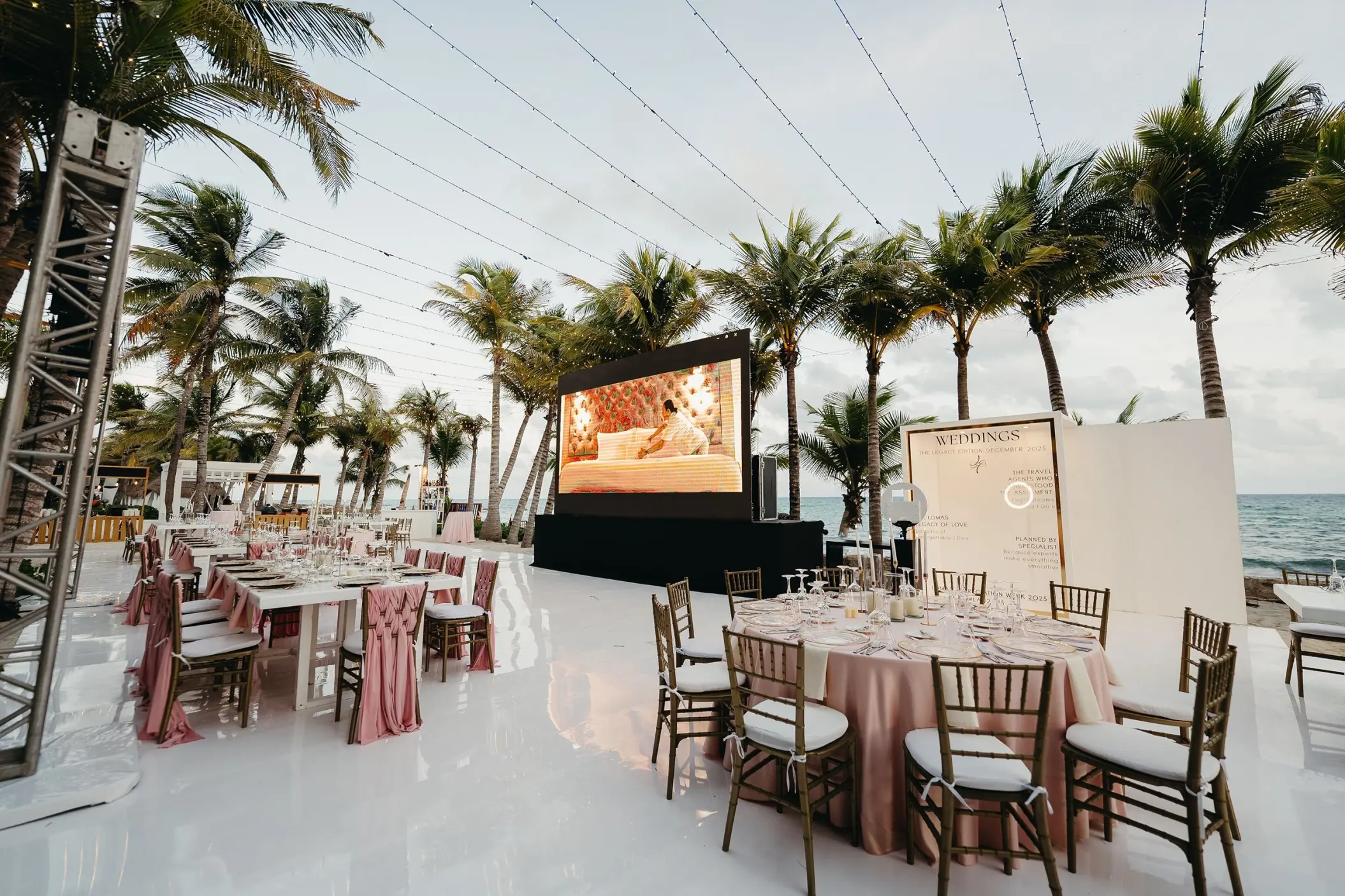 Outdoor wedding reception with large screen and pink decor at El Dorado Royale, Riviera Maya