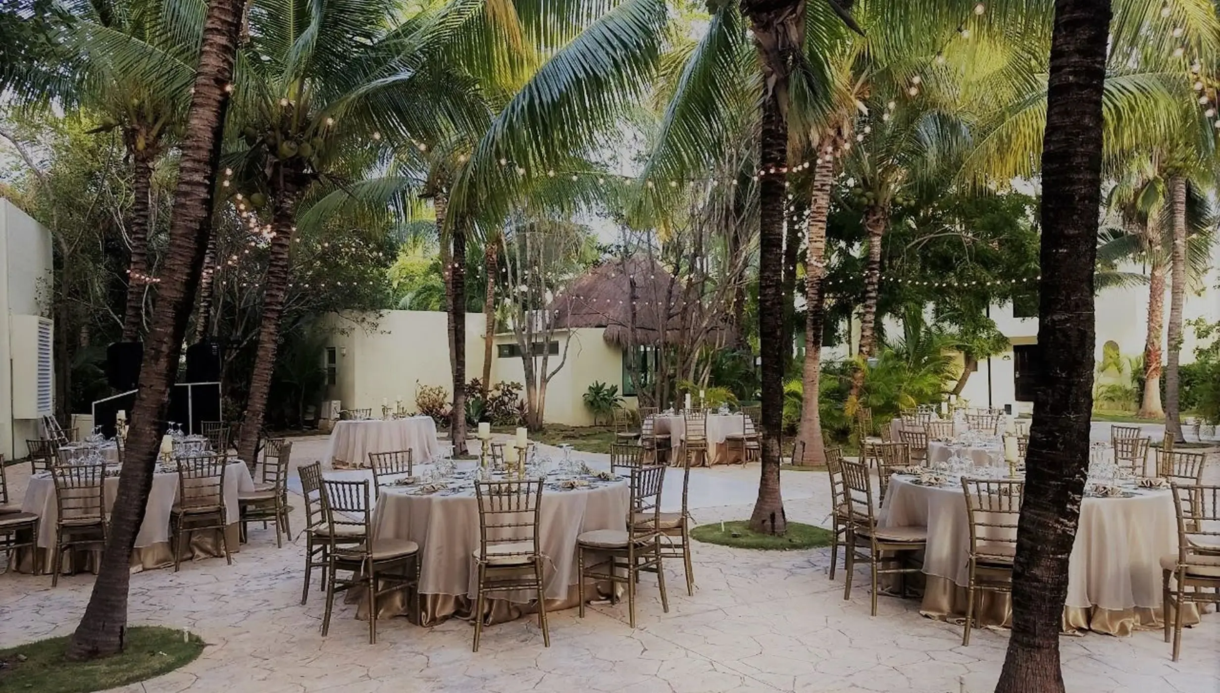 Outdoor wedding reception setup among palm trees at El Dorado Royale, Riviera Maya