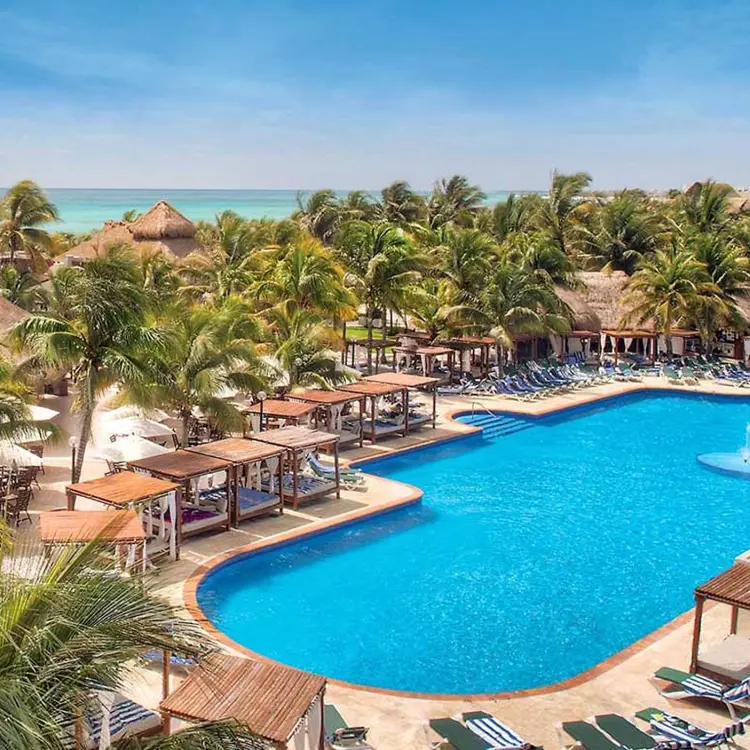 El Dorado Royale swimming pool surrounded by palm trees and cabanas, Riviera Maya