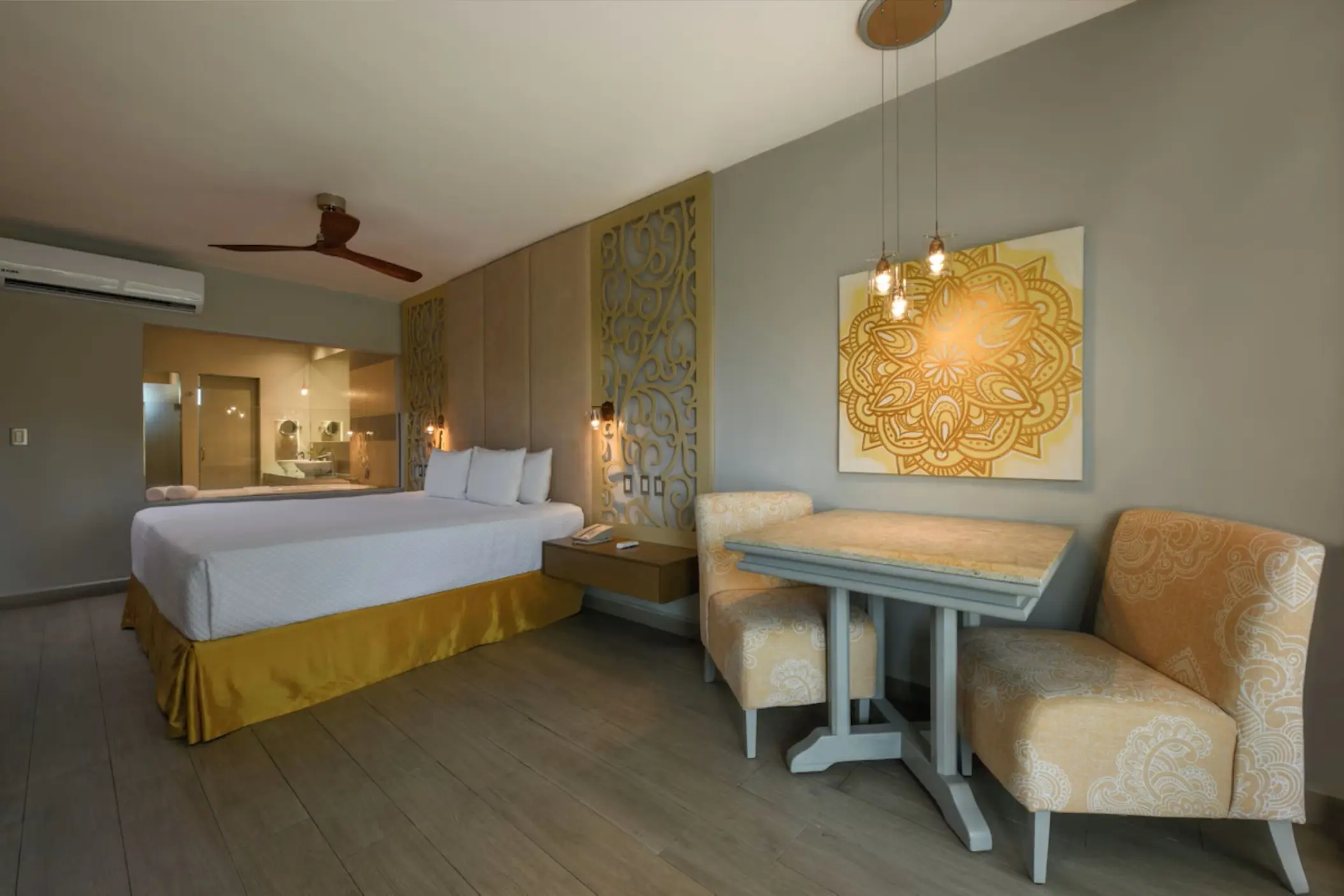 Modern guest suite with a king bed and dining area at El Dorado Royale, Riviera Maya