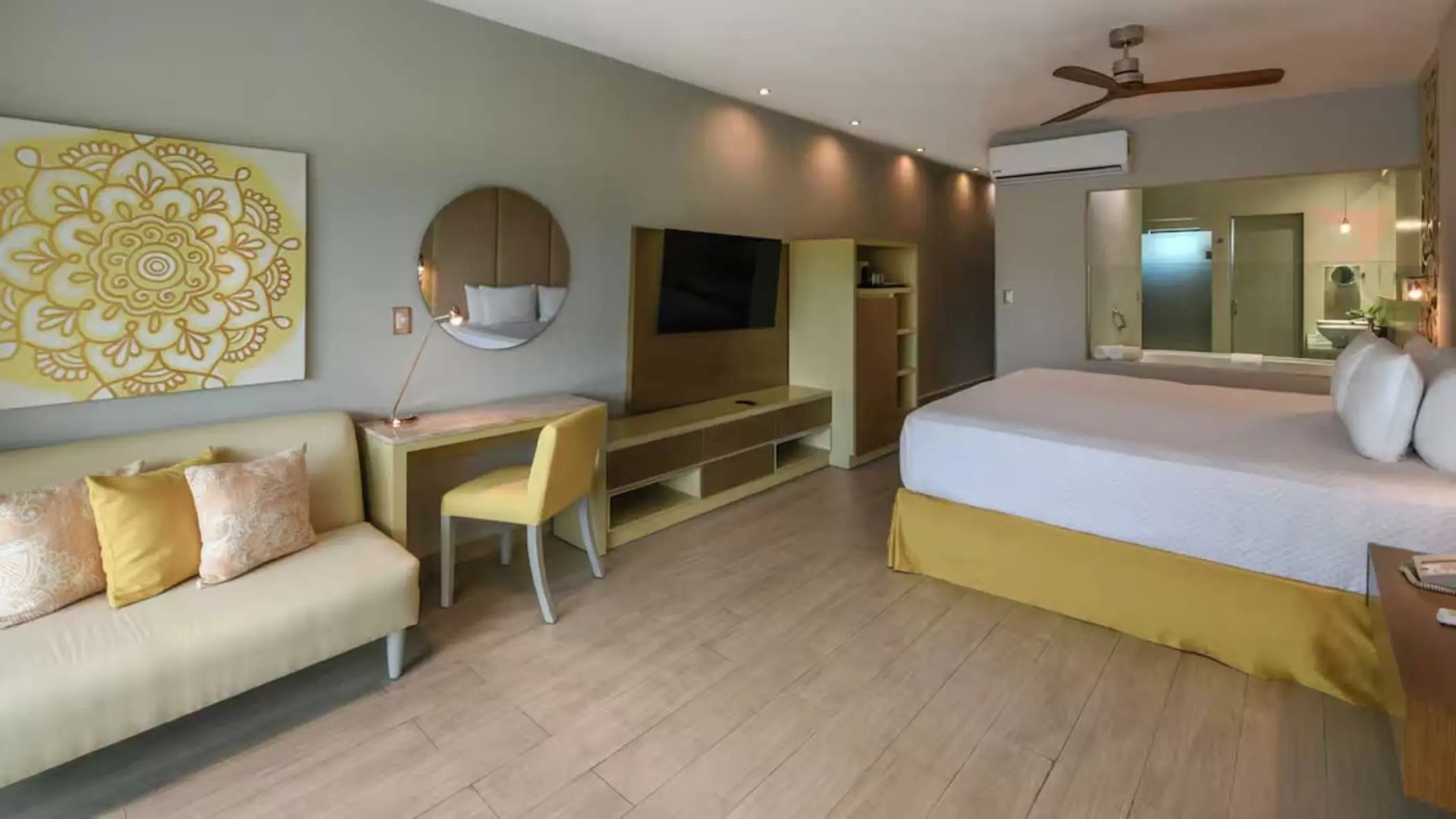 Modern suite with yellow accents and a view of the bathroom at El Dorado Royale, Riviera Maya