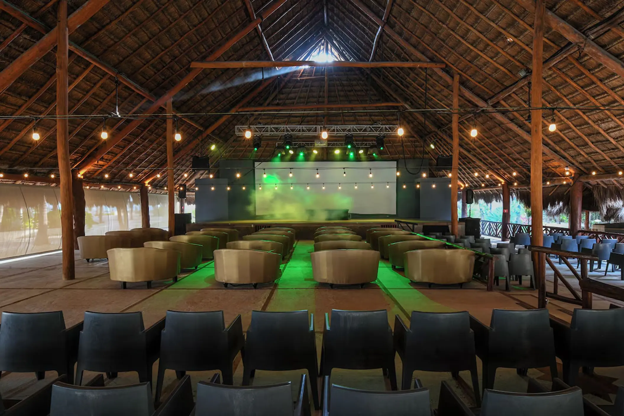 Theater stage with green lighting under a palapa roof at El Dorado Royale, Riviera Maya
