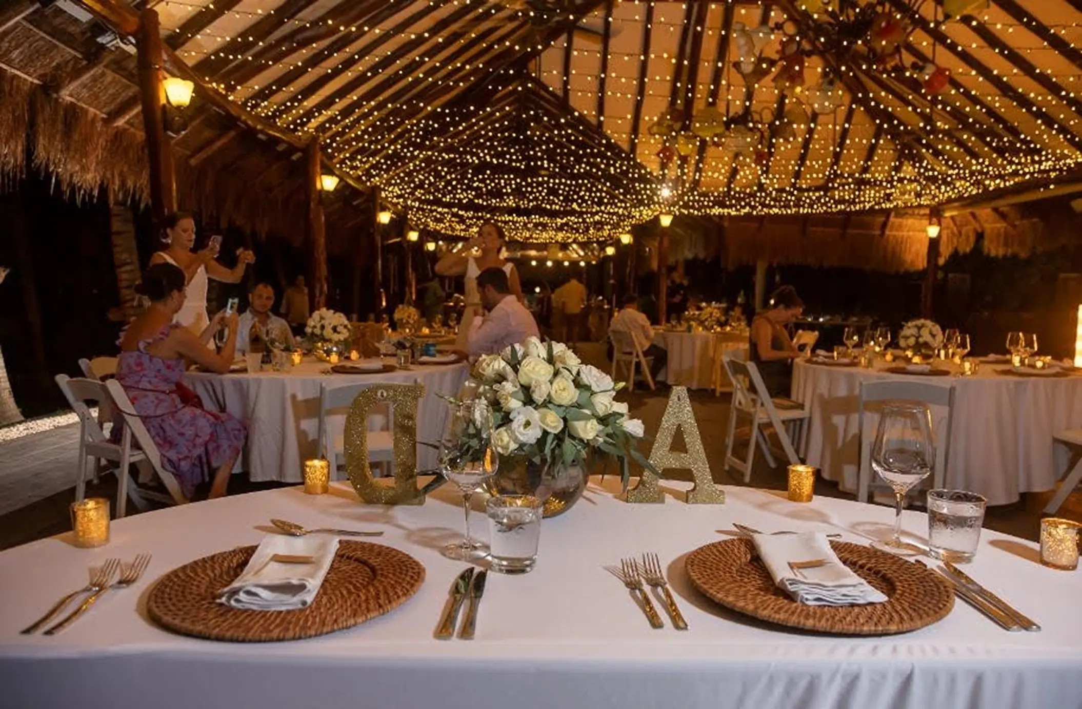 Wedding reception with fairy lights in a thatched palapa at El Dorado Royale, Riviera Maya