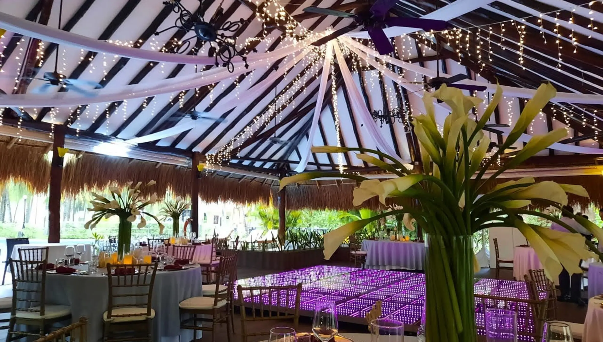 Indoor wedding reception with purple dance floor and fairy lights at El Dorado Royale, Riviera Maya