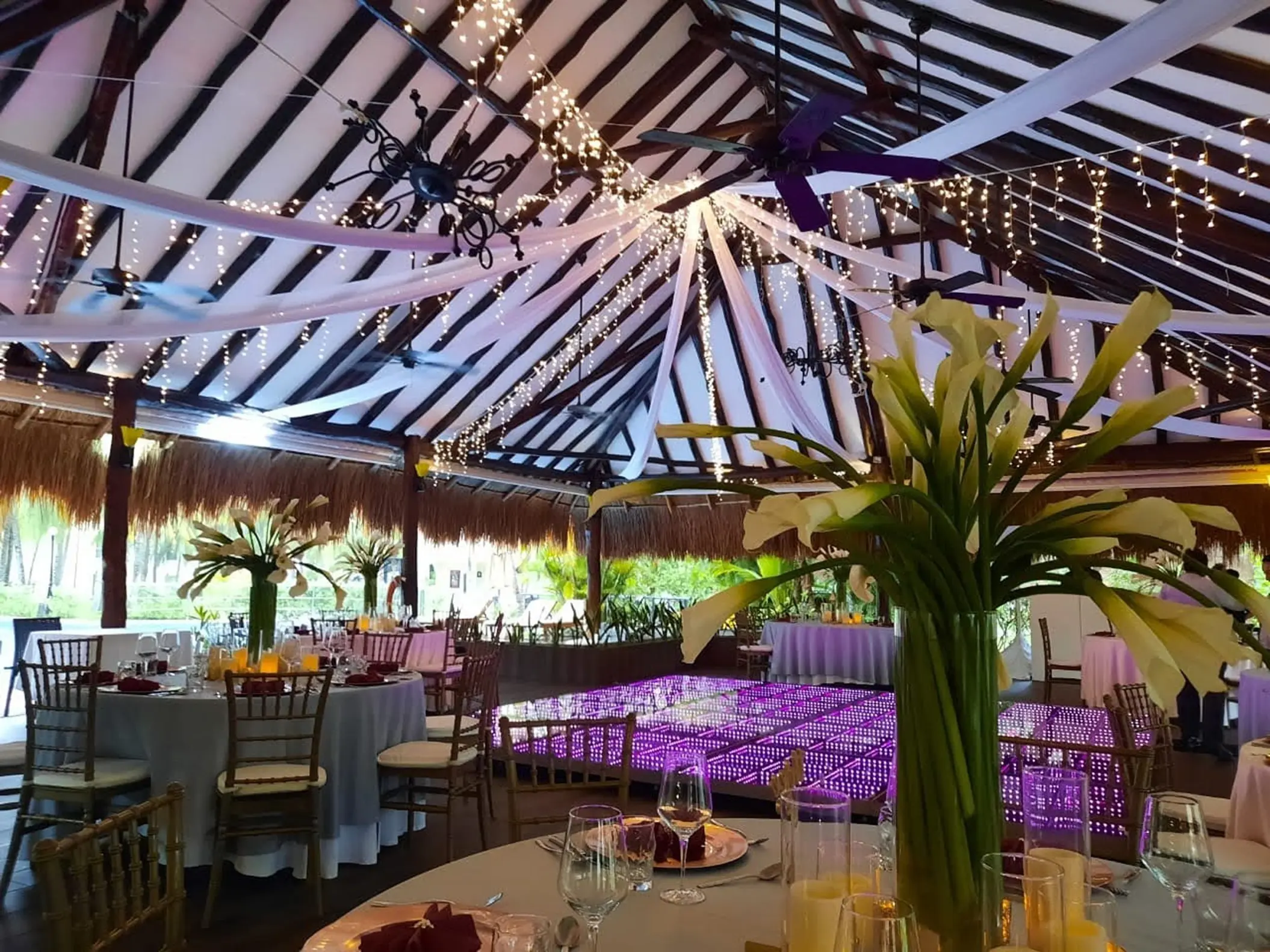 Indoor wedding reception with purple dance floor and fairy lights at El Dorado Royale, Riviera Maya
