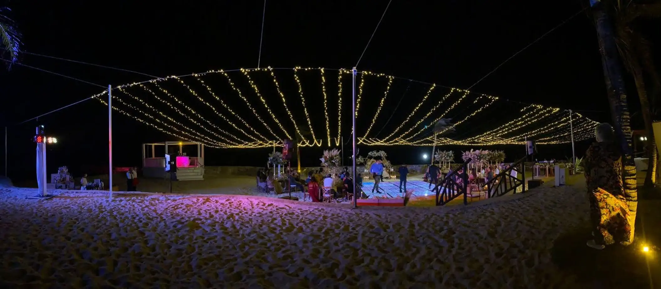 Beach wedding reception with string lights at night at El Dorado Royale, Riviera Maya