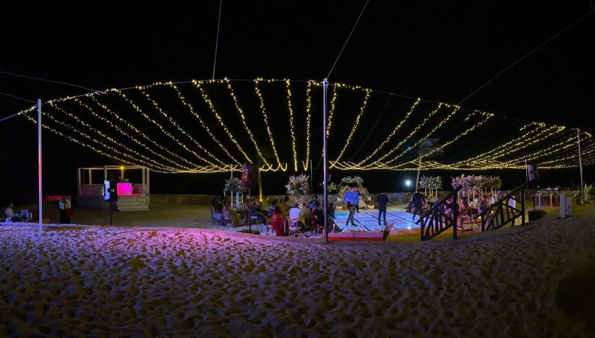 Beach wedding reception with string lights at night at El Dorado Royale, Riviera Maya