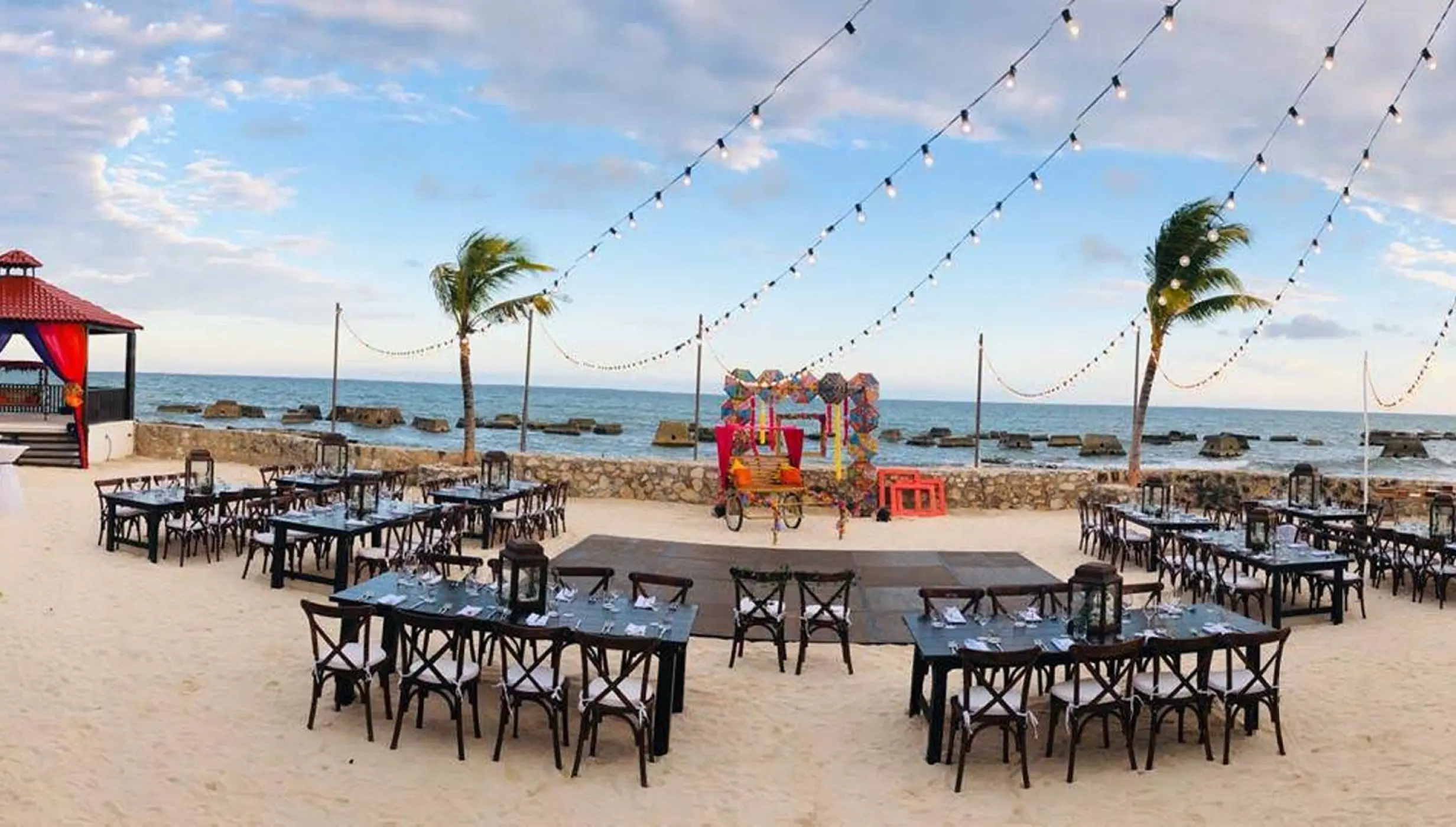 Beachfront wedding reception with string lights and a dance floor at El Dorado Royale, Riviera Maya