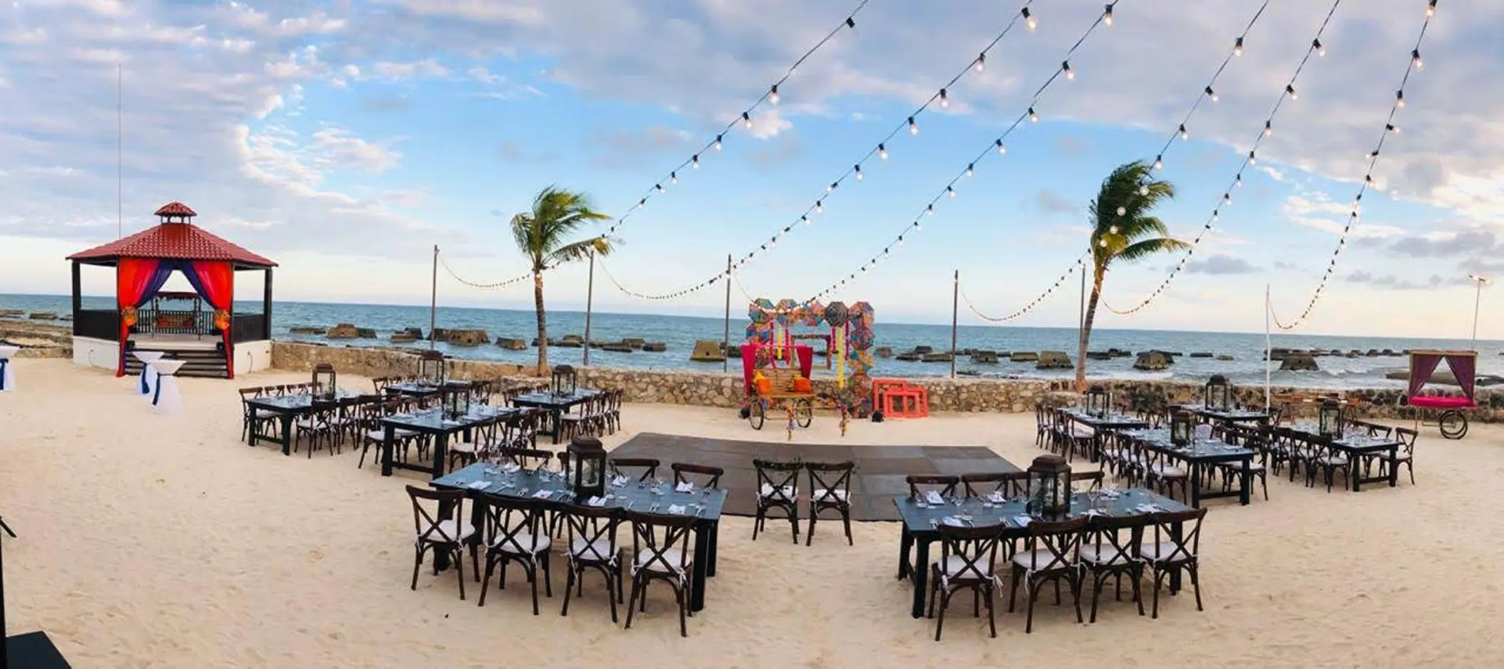 Beachfront wedding reception with string lights and a dance floor at El Dorado Royale, Riviera Maya