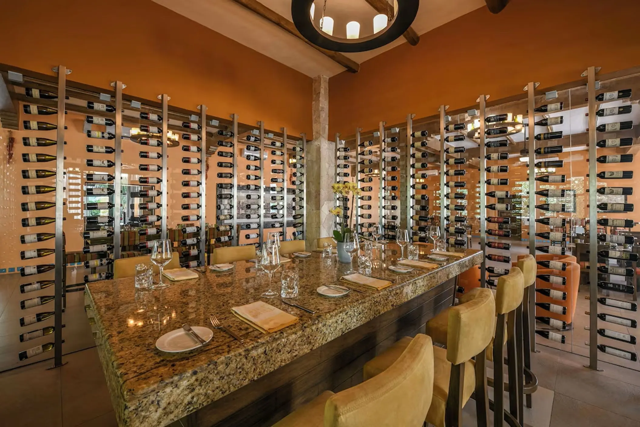Wine cellar dining table and floor-to-ceiling wine racks at El Dorado Royale, Riviera Maya