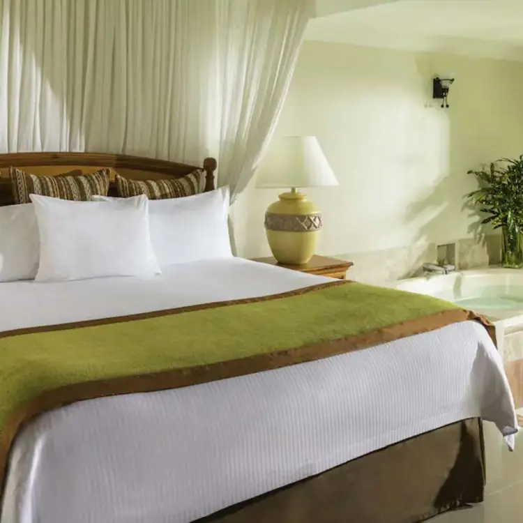 Suite with canopy bed and indoor hot tub at El Dorado Seaside Palms, Riviera Maya