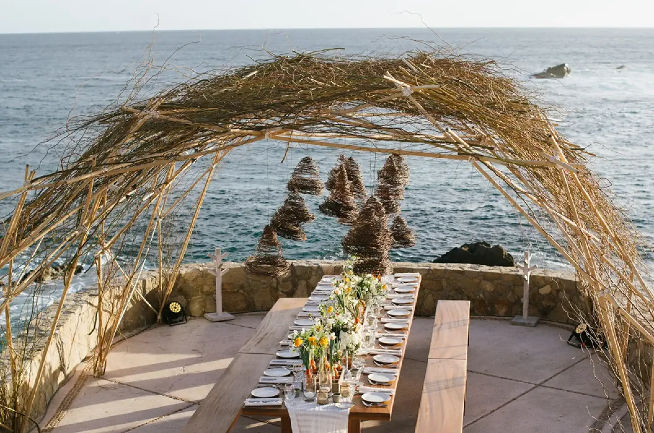 Oceanfront wedding reception under a twig arch at Esperanza, Cabo San Lucas