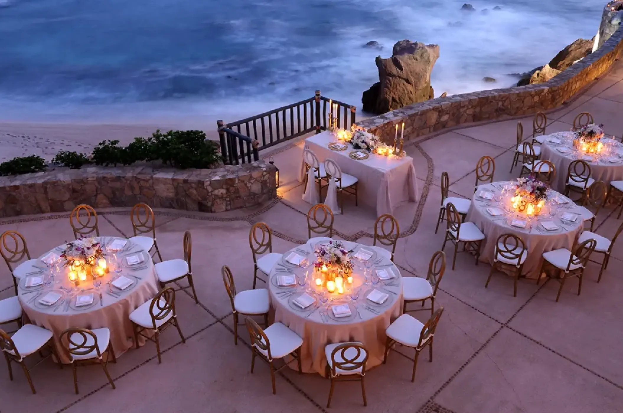 Evening cliffside wedding reception with candlelit tables at Esperanza, Cabo San Lucas