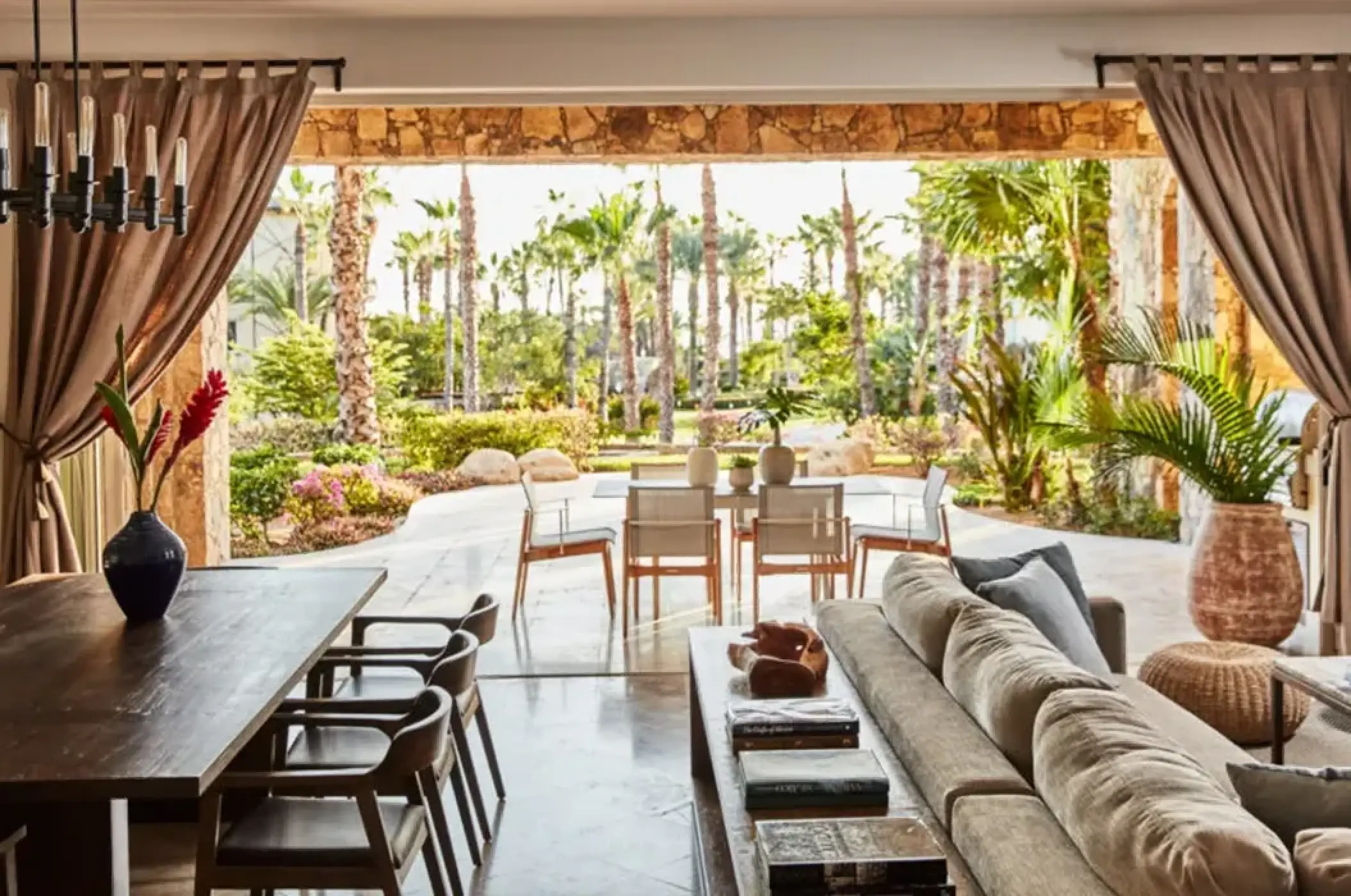 Outdoor lounge and dining area with palm tree views at Esperanza Cabo San Lucas