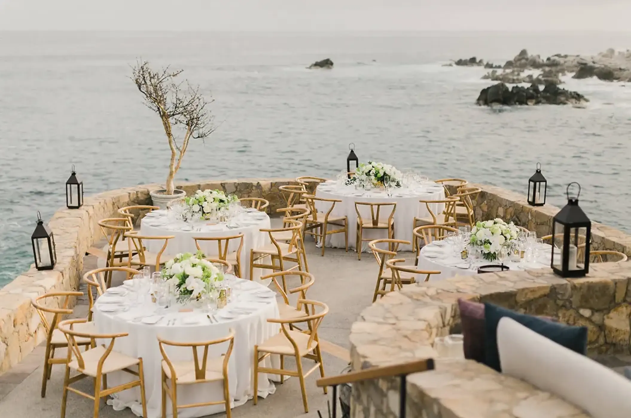 Clifftop wedding reception terrace with round tables at Esperanza Cabo San Lucas