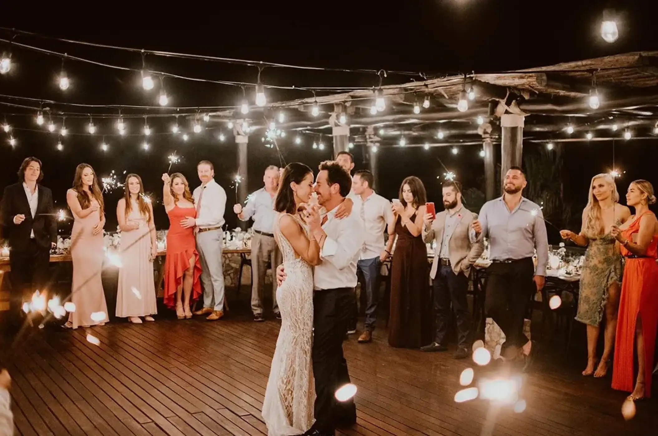 The couple dancing at a sparkler wedding reception under string lights at Esperanza, Cabo San Lucas